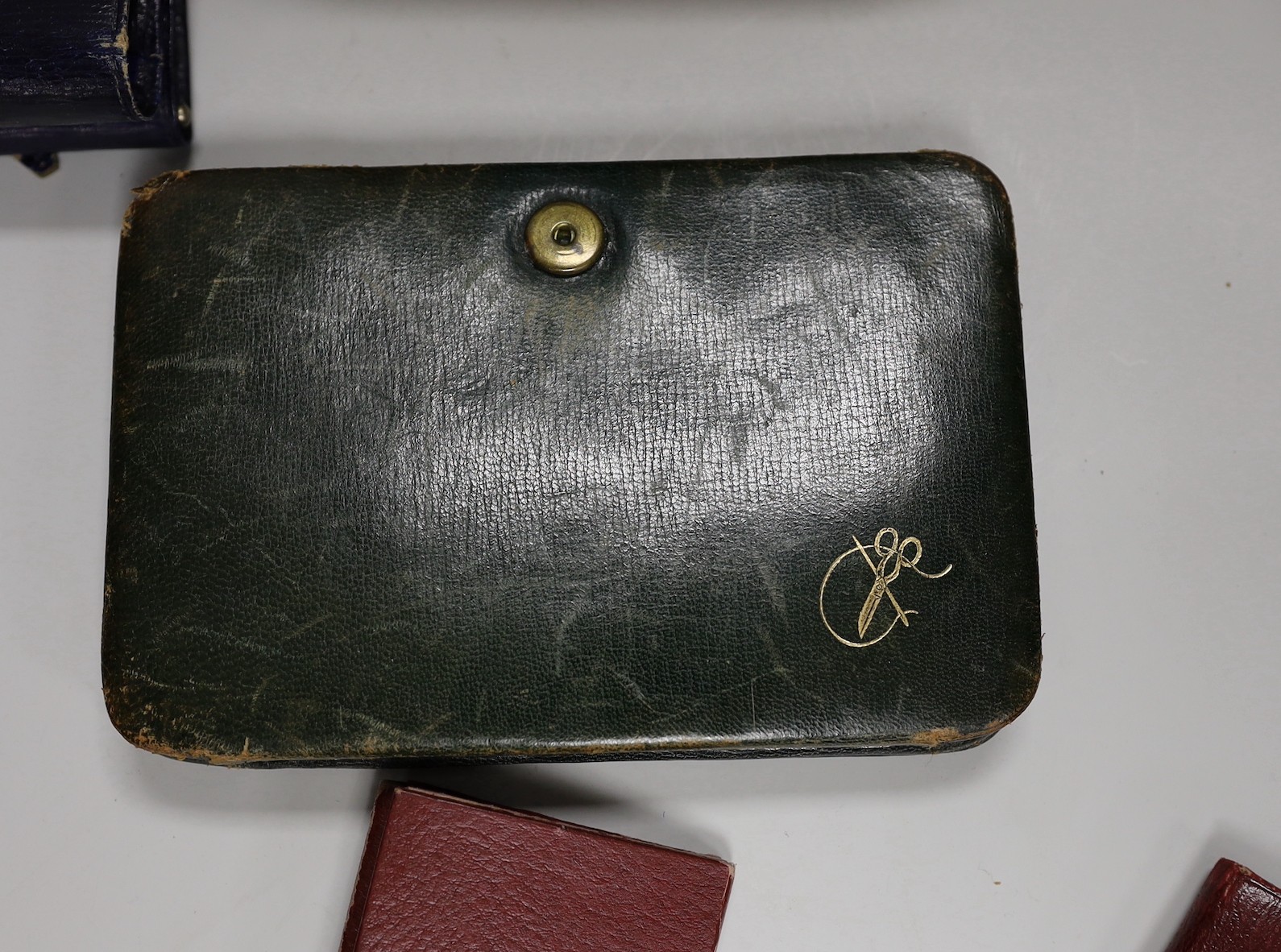 A suitcase containing a collection of late 19th century leather sewing bags and containers, wooden darning mushrooms, etc